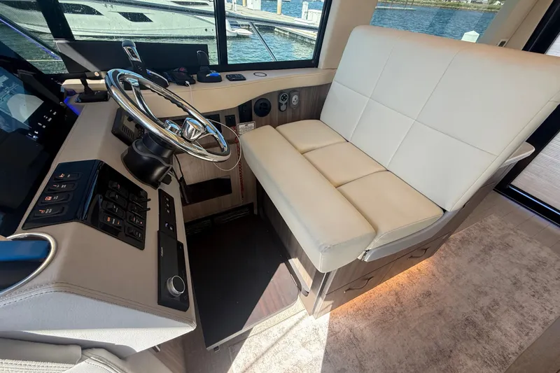 Slide: The Image of Interior helm of 2022 Regal 42 FXO yacht with steering wheel and controls. - 26