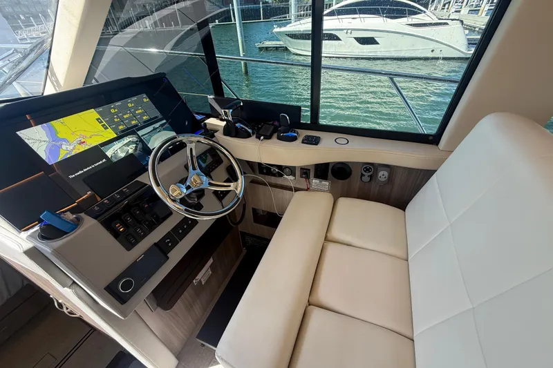 Slide: The Image of Interior helm of 2022 Regal 42 FXO yacht with navigation display and steering wheel. - 30