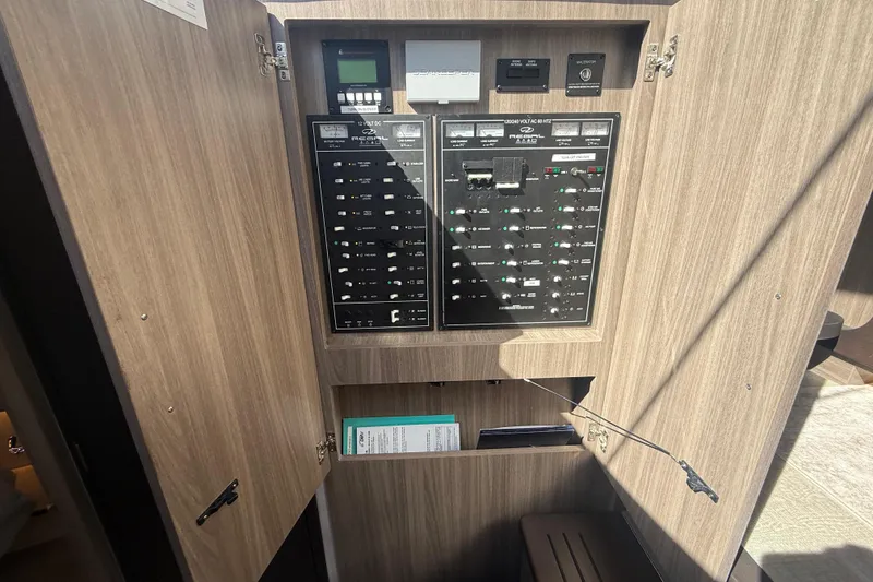 Slide: The Image of Electrical panel inside a 2022 Regal 42 FXO boat, featuring switches and controls. - 32