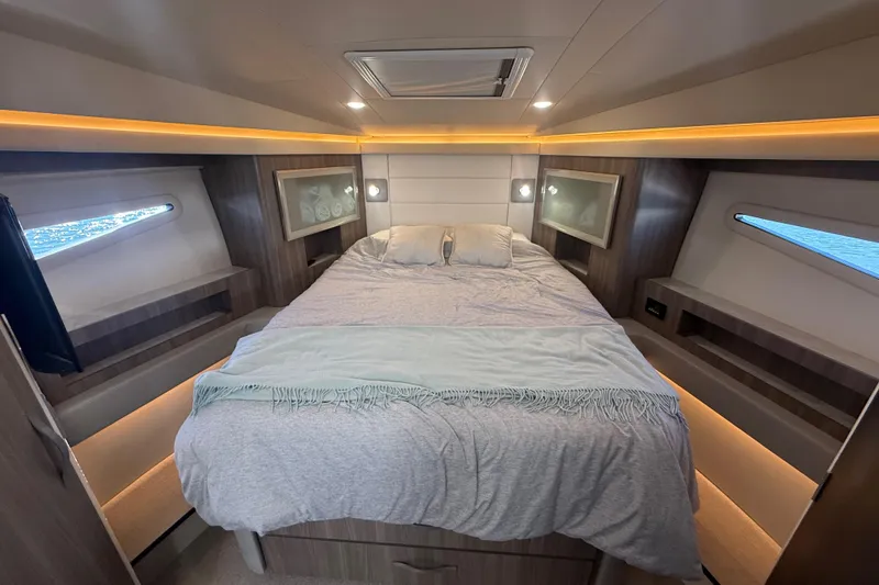 Slide: The Image of Luxurious cabin interior of 2022 Regal 42 FXO yacht with cozy bed and ambient lighting. - 38