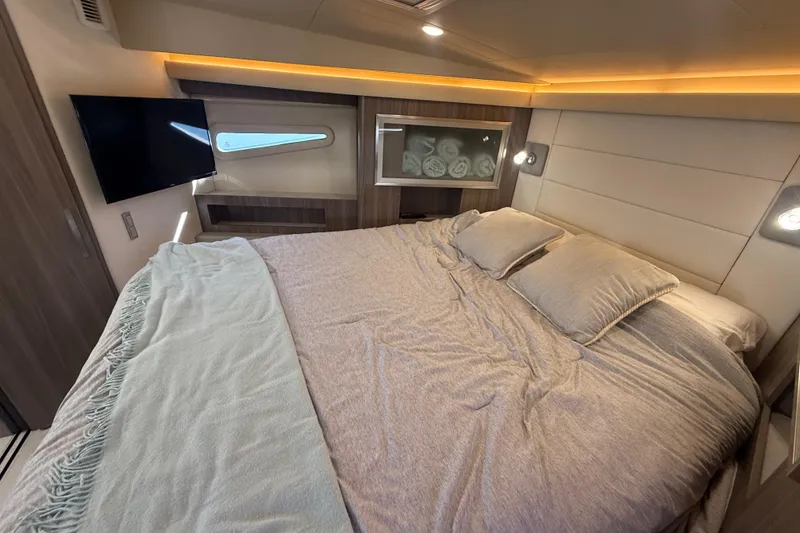 Slide: The Image of Luxurious bedroom interior of 2022 Regal 42 FXO yacht with cozy bedding and ambient lighting. - 39