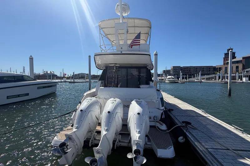 Slide: The Image of 2022 Regal 42 FXO yacht docked at marina with triple outboard engines. - 4