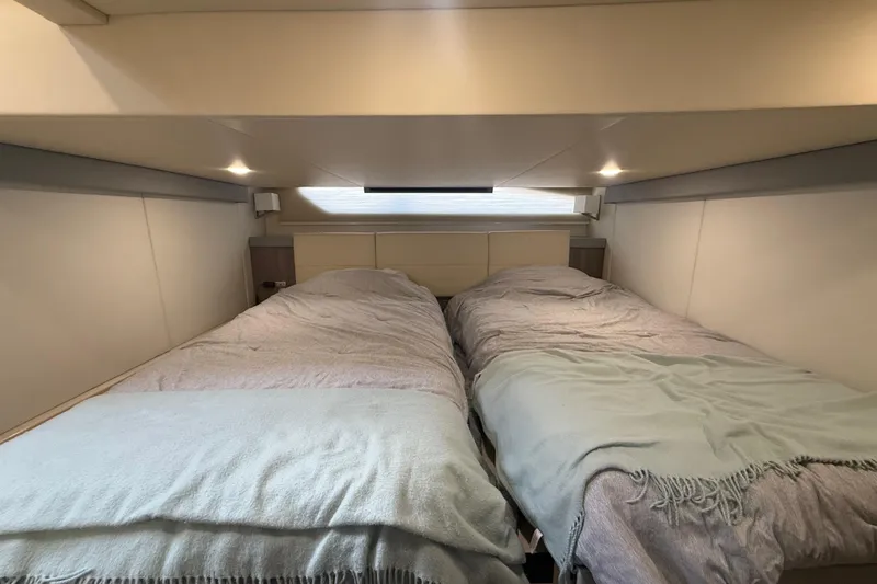 Slide: The Image of Interior cabin of 2022 Regal 42 FXO yacht with twin beds and soft lighting. - 41