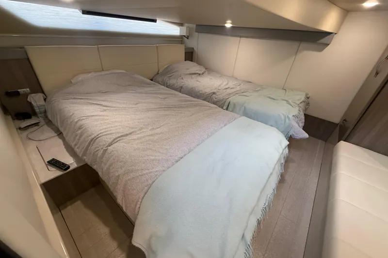 Slide: The Image of Interior cabin of 2022 Regal 42 FXO yacht with twin beds and modern decor. - 42