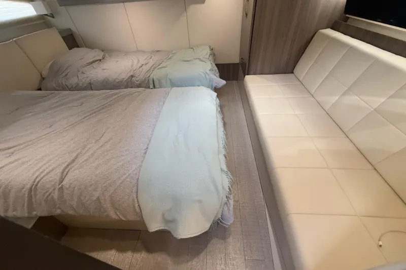Slide: The Image of Interior of 2022 Regal 42 FXO yacht with twin beds and a white sofa. - 44