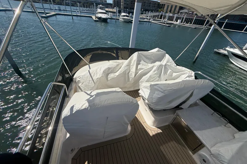 Slide: The Image of 2022 Regal 42 FXO yacht interior with covered seating at marina dock. - 7