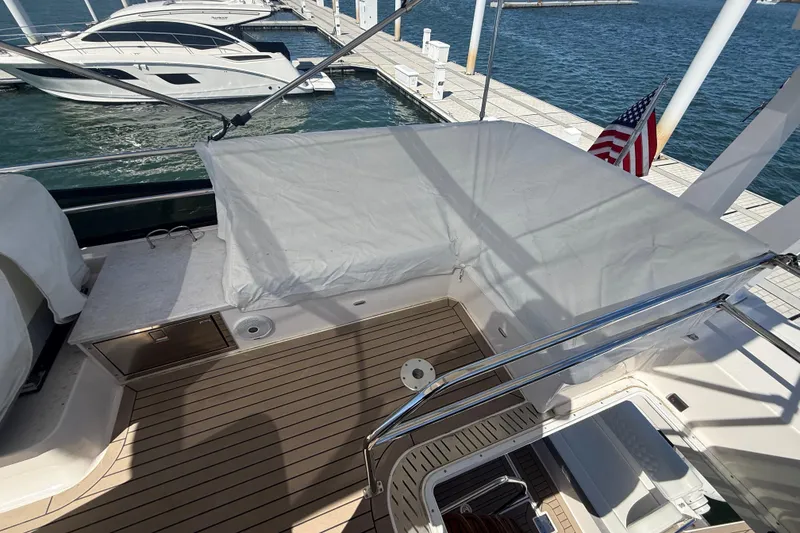 Slide: The Image of 2022 Regal 42 FXO yacht deck with covered seating, docked at marina. - 8