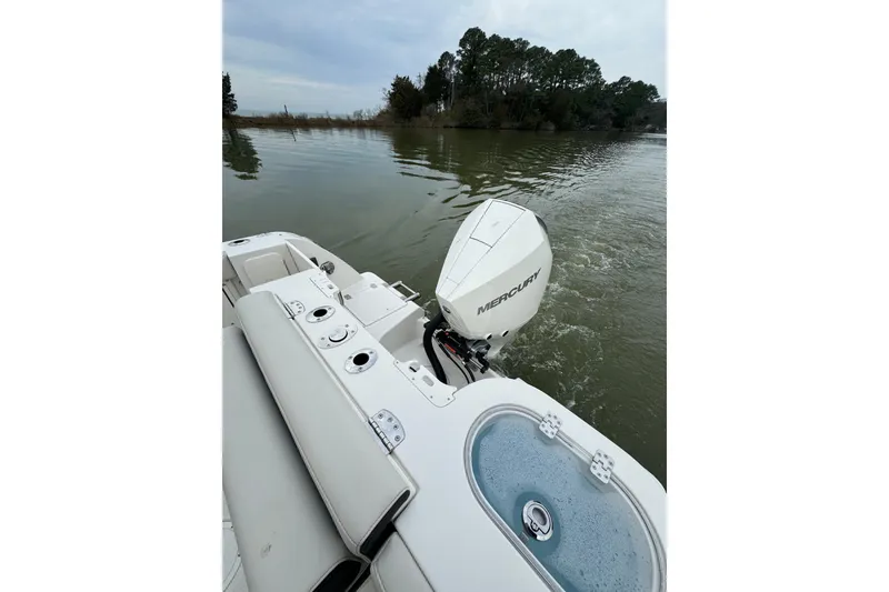 Slide: The Image of 2024 Sailfish 245 DC boat with Mercury outboard motor on calm water. - 45