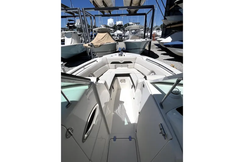 Slide: The Image of 2024 Sailfish 245 DC boat interior with seating, docked among other boats. - 16