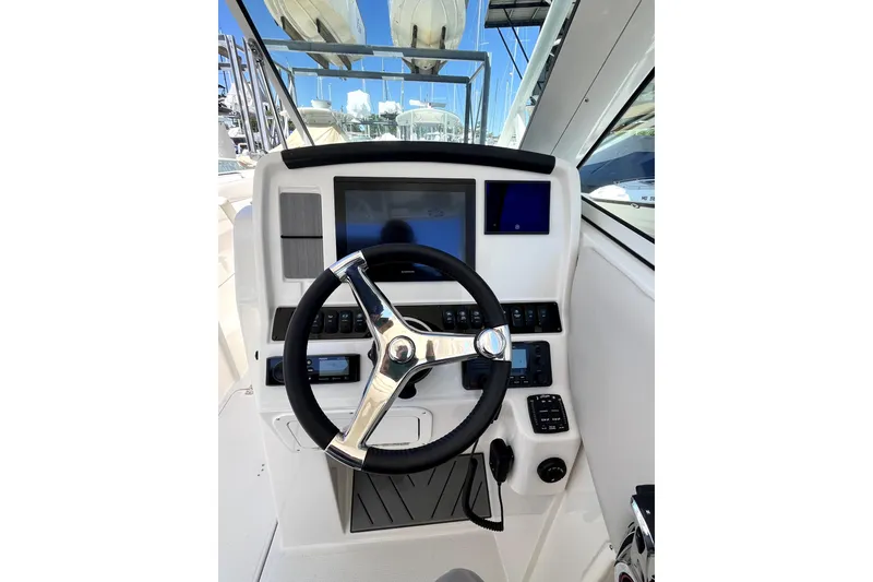 Slide: The Image of 2024 Sailfish 245 DC boat helm with modern steering wheel and electronic controls. - 37