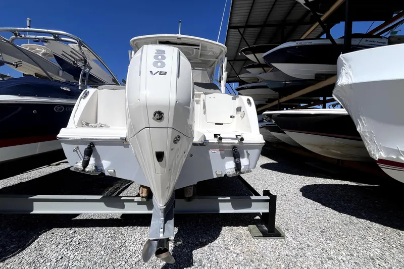 Slide: The Image of 2024 Sailfish 245 DC boat with 300 V8 engine, displayed in a marina. - 4