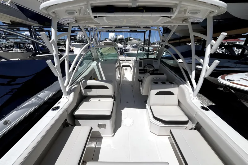 Slide: The Image of 2024 Sailfish 245 DC boat interior with seating and helm, docked at marina. - 11