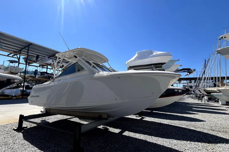 Slide: The Image of 2024 Sailfish 245 DC boat displayed outdoors under clear blue sky. - 1
