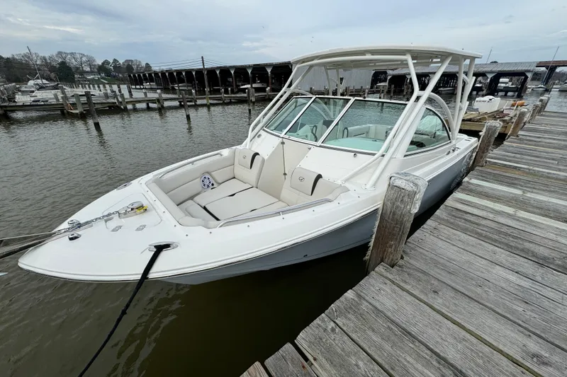 Slide: The Image of 2024 Sailfish 245 DC boat docked at a marina, showcasing sleek design and spacious seating. - 2