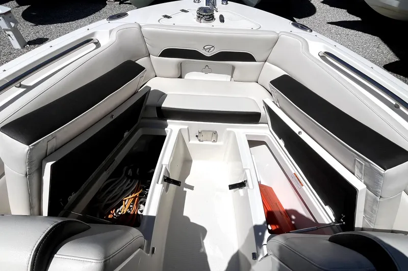 Slide: The Image of 2024 Sailfish 245 DC boat interior with open storage compartments and cushioned seating. - 18