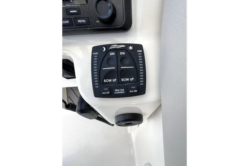 Slide: The Image of 2024 Sailfish 245 DC boat trim tab control panel with buttons and indicators. - 35
