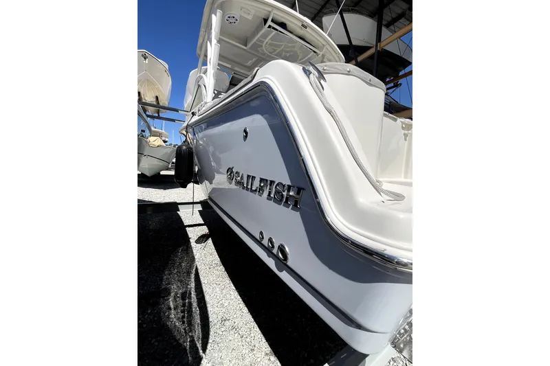 Slide: The Image of 2024 Sailfish 245 DC boat, sleek design, docked under clear blue sky. - 8