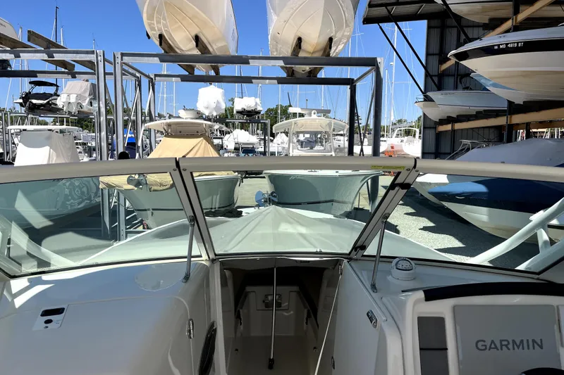 Slide: The Image of 2024 Sailfish 245 DC boat in marina, surrounded by other docked boats. - 31
