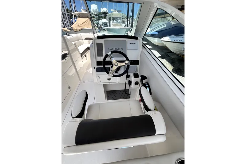 Slide: The Image of 2024 Sailfish 245 DC boat cockpit with Garmin navigation system and comfortable seating. - 15