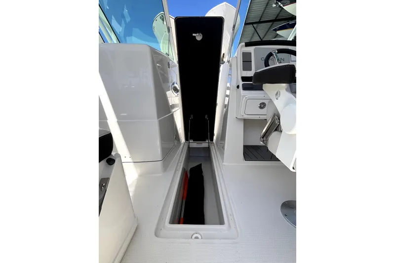 Slide: The Image of 2024 Sailfish 245 DC boat interior with open storage compartment and helm station. - 38