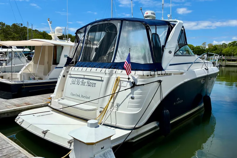 The Image of 2006 Rinker 390 Express Cruiser docked, featuring a sleek design and American flag. - 0
