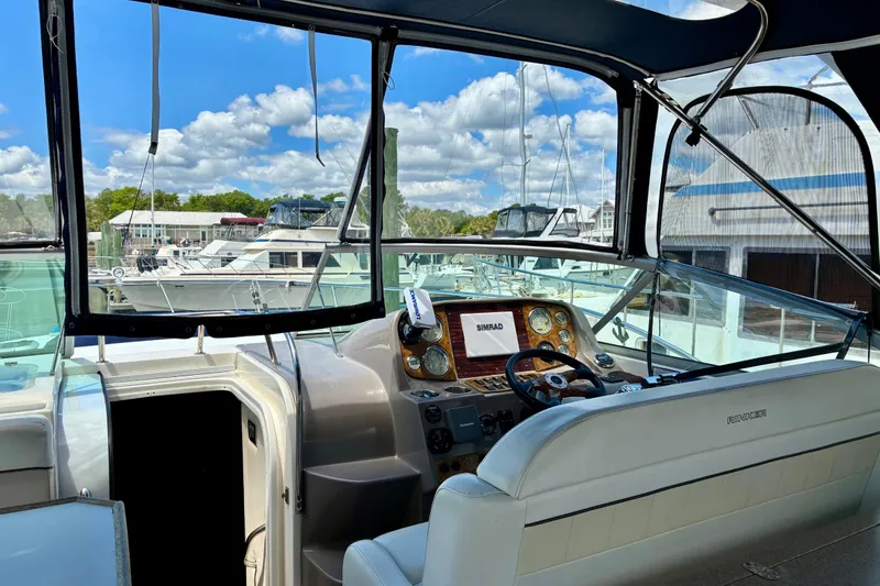 Slide: The Image of 2006 Rinker 390 Express Cruiser cockpit with steering wheel and navigation equipment. - 11