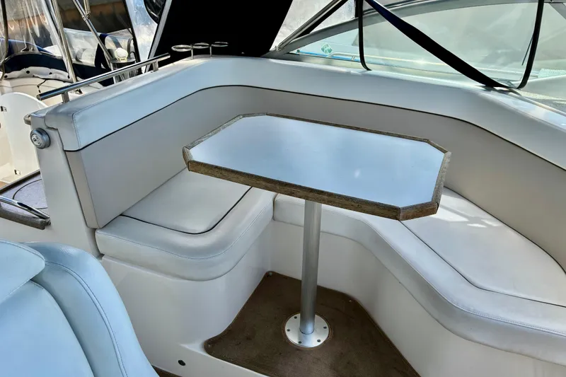 Slide: The Image of 2006 Rinker 390 Express Cruiser interior with white seating and table. - 12