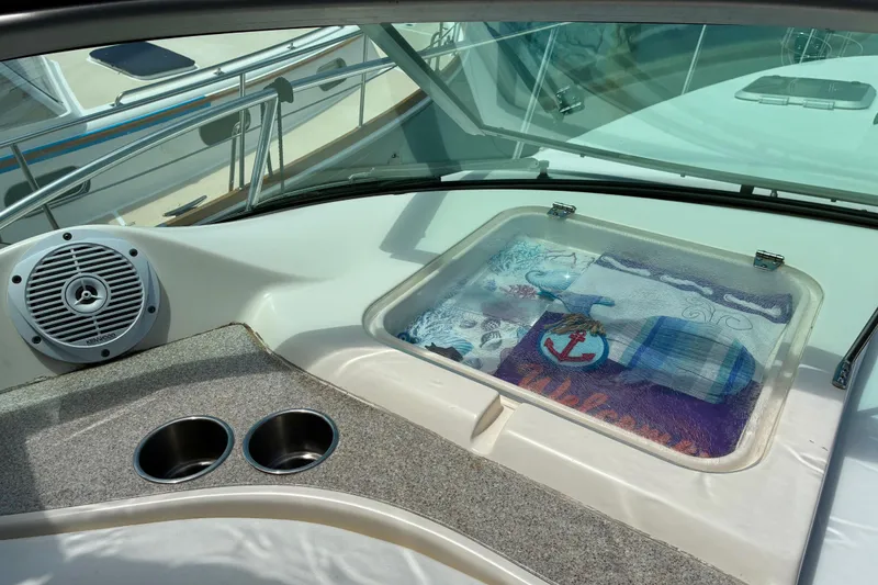 Slide: The Image of 2006 Rinker 390 Express Cruiser interior with speaker, cup holders, and nautical-themed decor. - 13