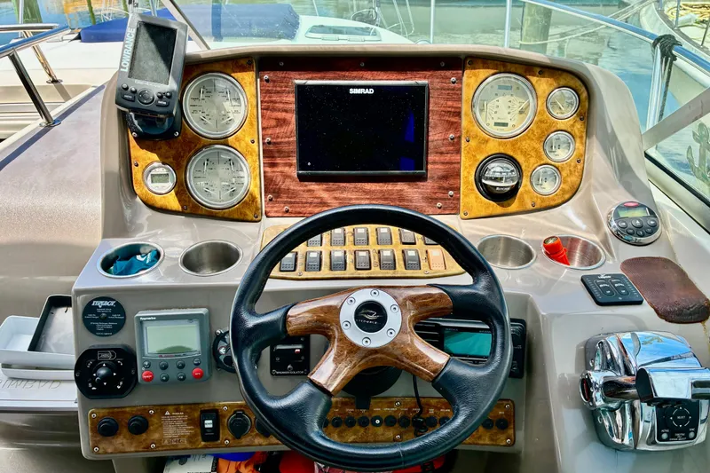 Slide: The Image of 2006 Rinker 390 Express Cruiser helm with navigation instruments and wooden steering wheel. - 16