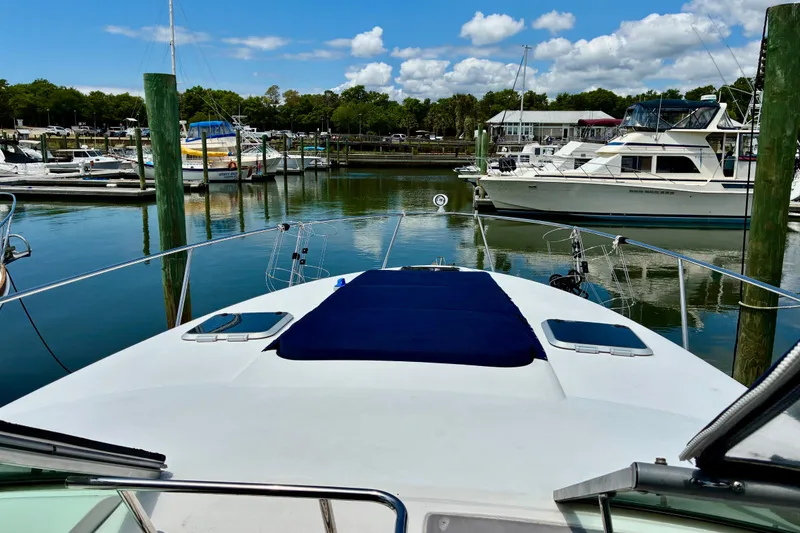 Slide: The Image of 2006 Rinker 390 Express Cruiser docked at a marina, surrounded by other boats. - 17