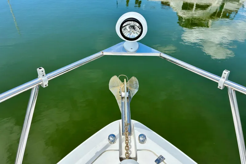 Slide: The Image of Bow view of 2006 Rinker 390 Express Cruiser with anchor and spotlight on calm water. - 18