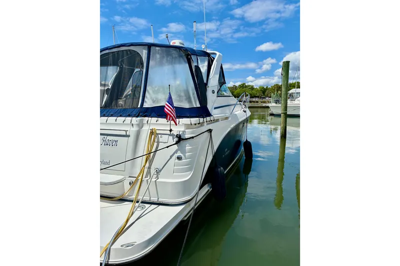 Slide: The Image of 2006 Rinker 390 Express Cruiser docked, featuring sleek design and American flag. - 2