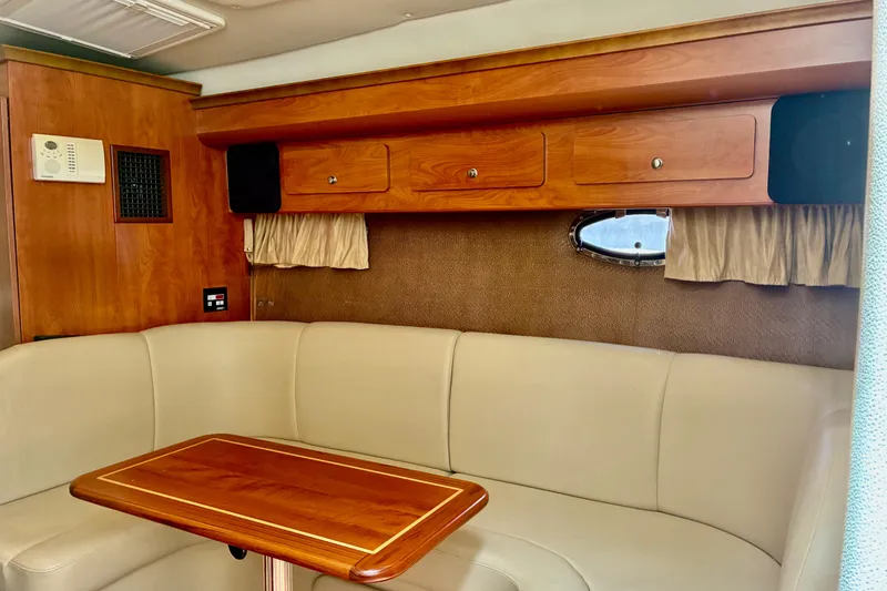 Slide: The Image of Interior of 2006 Rinker 390 Express Cruiser with wood cabinetry and beige seating. - 24