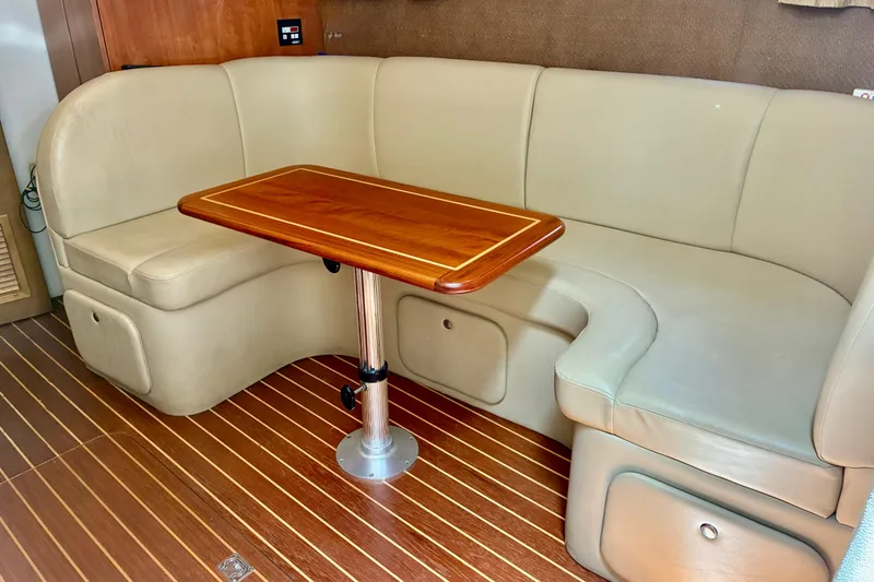 Slide: The Image of 2006 Rinker 390 Express Cruiser interior with beige seating and wooden table. - 25