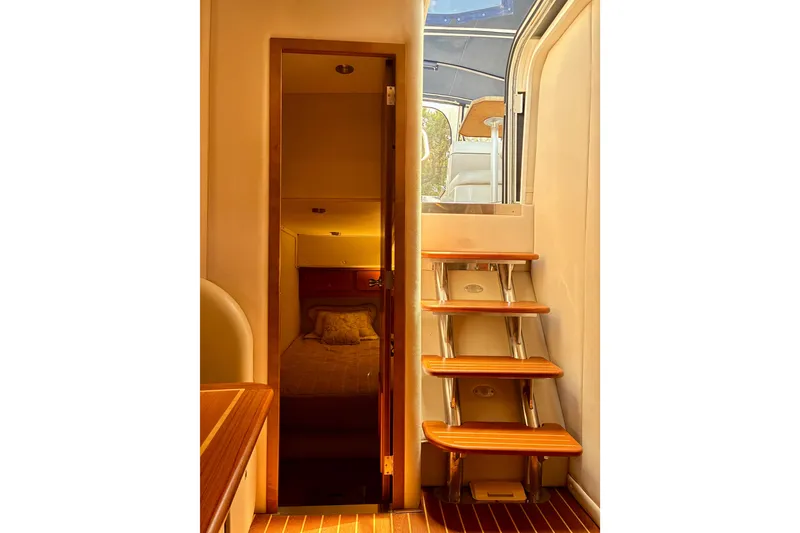 Slide: The Image of Interior view of 2006 Rinker 390 Express Cruiser with wooden steps and cozy cabin. - 26
