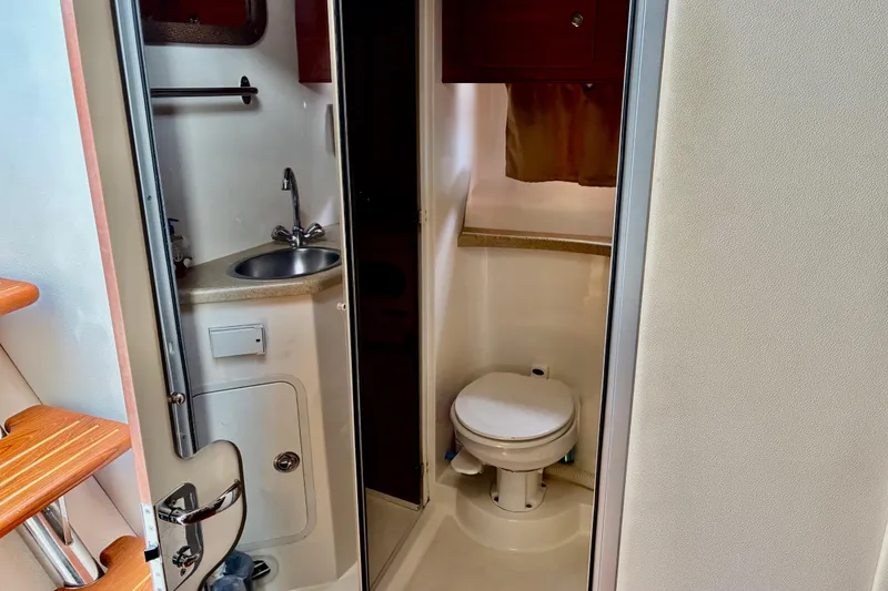 Slide: The Image of 2006 Rinker 390 Express Cruiser bathroom with sink, toilet, and wooden steps. - 30