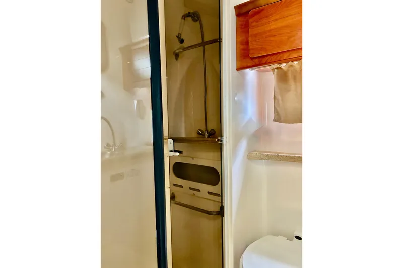 Slide: The Image of 2006 Rinker 390 Express Cruiser bathroom with shower, wooden cabinet, and sink. - 31
