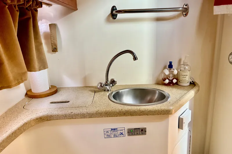 Slide: The Image of 2006 Rinker 390 Express Cruiser bathroom sink with countertop, faucet, and toiletries. - 32