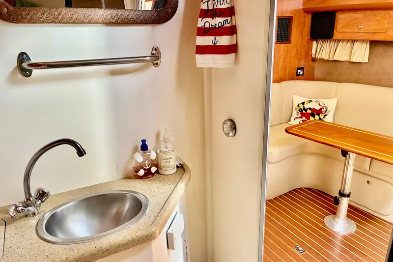 Slide: The Image of 2006 Rinker 390 Express Cruiser interior with sink, towel, and cozy seating area. - 33