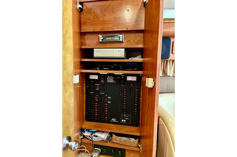 Slide: The Image of Electrical panel inside 2006 Rinker 390 Express Cruiser, featuring control switches and audio equipment. - 34