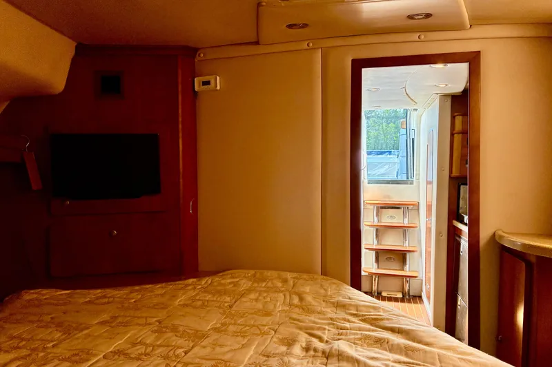 Slide: The Image of Interior of 2006 Rinker 390 Express Cruiser, featuring cozy cabin with bed and TV. - 38
