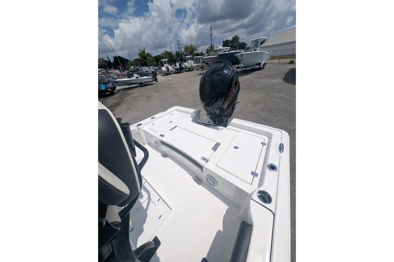 Slide: The Image of 2026 Tidewater 2300 Carolina Bay boat with motor, parked outdoors under cloudy sky. - 11