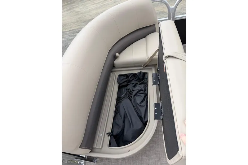 Slide: The Image of 2025 Sun Tracker Party Barge 16 DLX storage compartment with open seat revealing interior space. - 47
