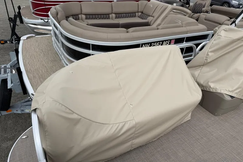 Slide: The Image of 2025 Sun Tracker Party Barge 16 DLX with beige seating and protective covers. - 52