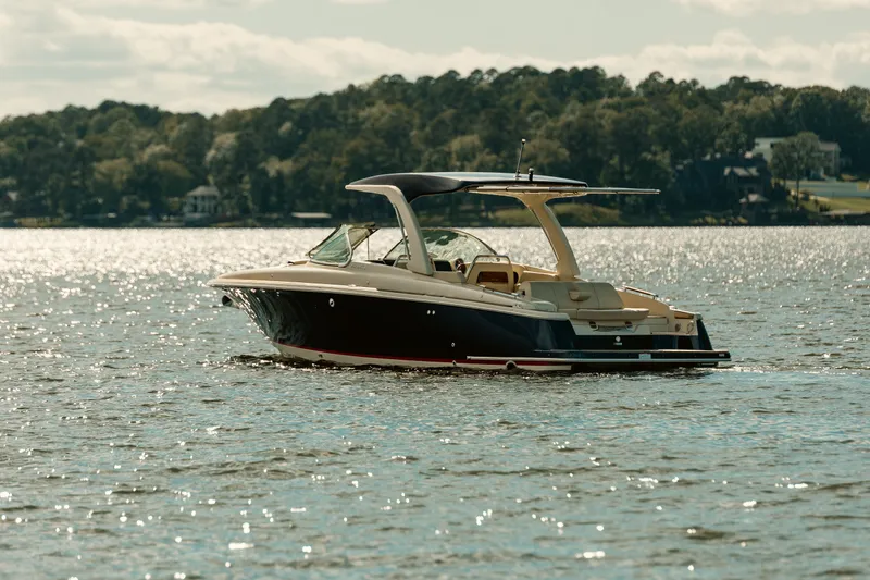 Slide: The Image of 2020 Chris-Craft Launch 31 GT boat on trailer, sleek design, American flag, outdoors. - 2