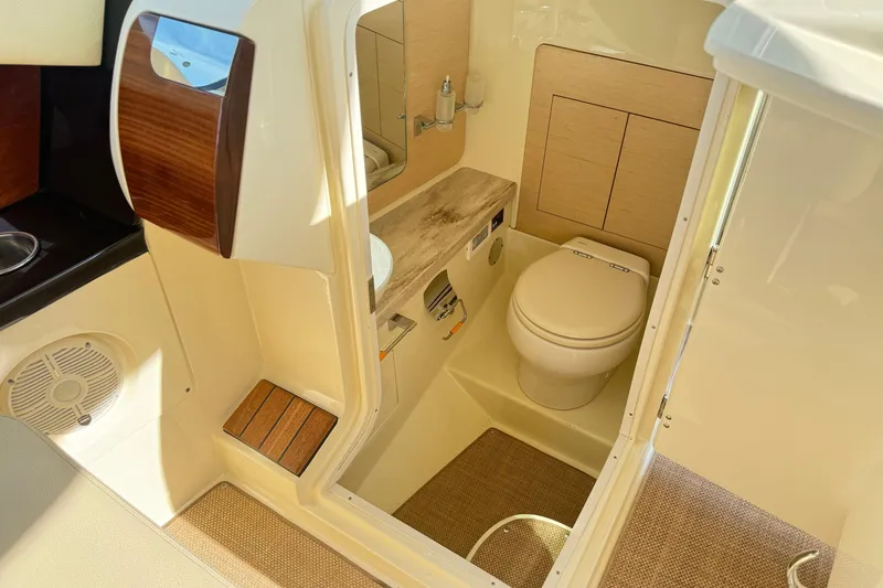 Slide: The Image of 2020 Chris-Craft Launch 31 GT boat interior with compact bathroom and wooden accents. - 24