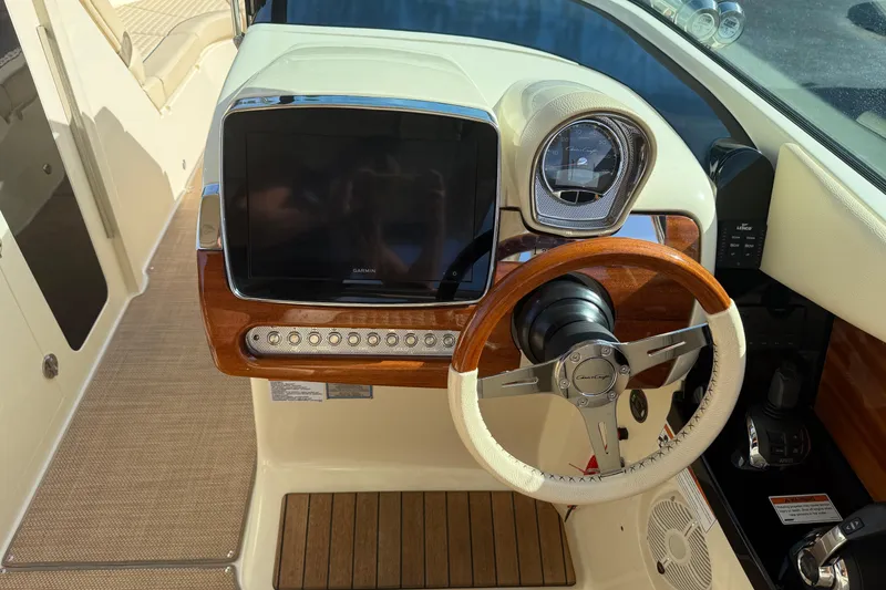 Slide: The Image of 2020 Chris-Craft Launch 31 GT dashboard with wooden steering wheel and modern controls. - 26
