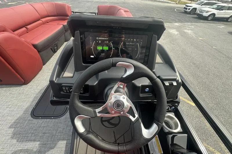 Slide: The Image of Steering console of 2026 Regency 230 DL boat with digital display and red seating. - 13