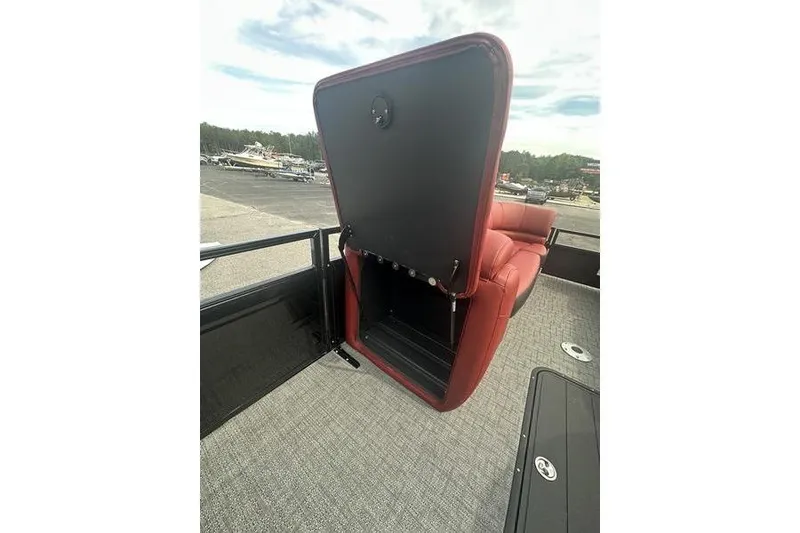 Slide: The Image of 2026 Regency 230 DL boat with open storage compartment and red seating. - 14