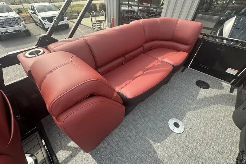 Slide: The Image of Red leather seating on 2026 Regency 230 DL boat, featuring cup holder and carpeted floor. - 3